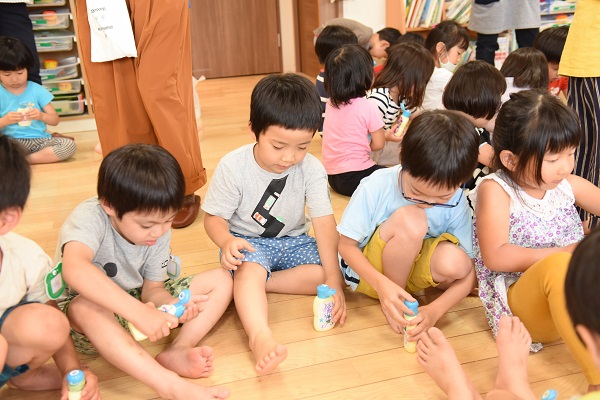 足に日焼け止めを塗っている子どもたち