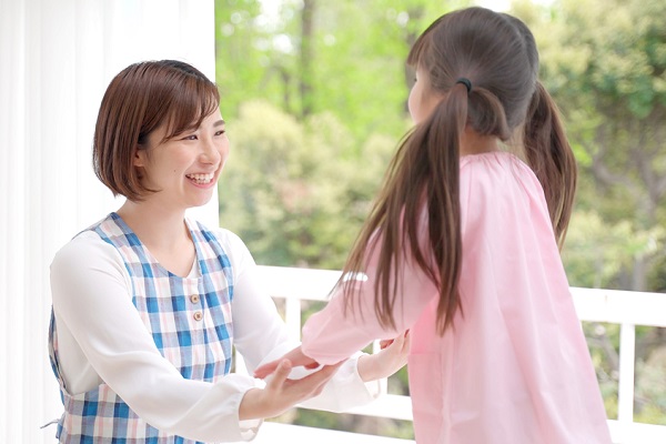 笑顔の保育士と子どもの写真