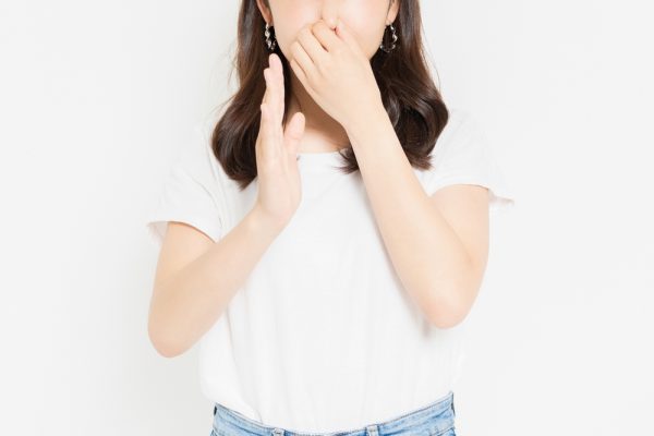 鼻をつまむ女性