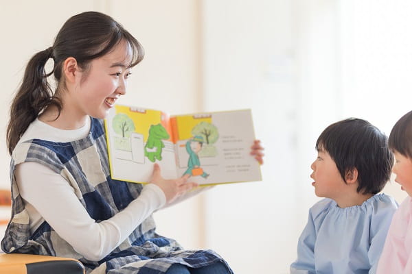 絵本を読み聞かせる保育士