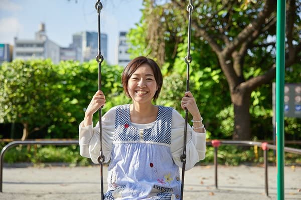 ブランコに乗る保育士