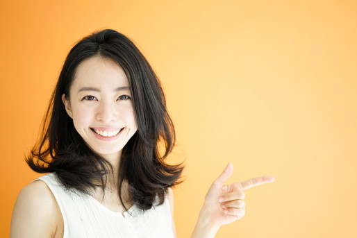 指をさす笑顔の女性
