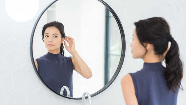 鏡の前に立つ女性