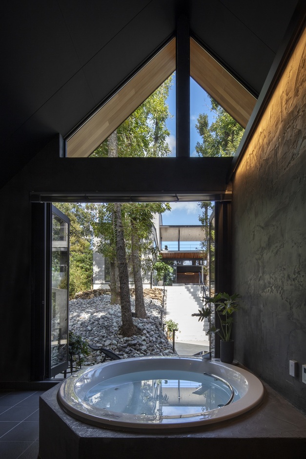 大きな窓から自然光が差し込むバスルーム。外の緑を眺めながらリラックスした時間を過ごせる、一日の疲れを癒す特別な空間である。【くふうイエタテ】