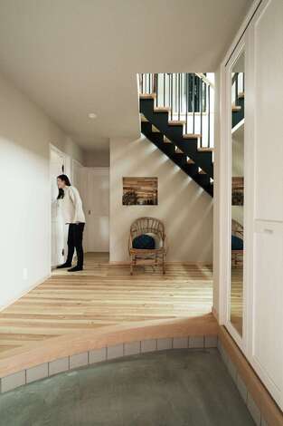 憧れていた広い玄関 上がりかまちは 直線にする意味はあるの というご主人の素朴な疑問からアールを付けた 吹き抜けの鉄骨階段と正面のニッチの