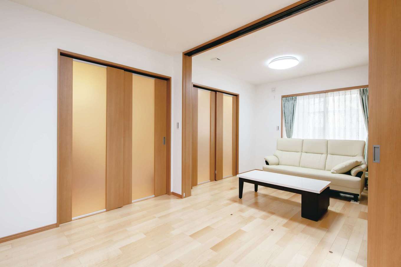 半透明の引き戸でダイニングと仕切った状態のリビング。スペースの真ん中にはさらに引き戸があり、リビング内を2部屋に