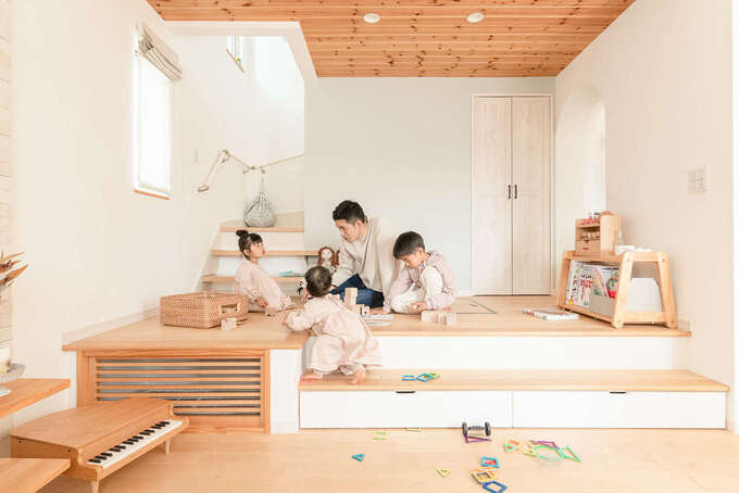 リビングの一画に設けた小上がり 階段への動線も兼ね さらにキッチン側にもアーチを抜けて行き来できる間取り 今はキッズスペースとして大活躍 床