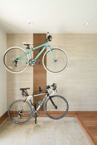 夫妻の自転車をディスプレイできる玄関は 土間部分でメンテナンスができるほど広々 階段脇には手洗い専用の洗面台を造作した イエタテ