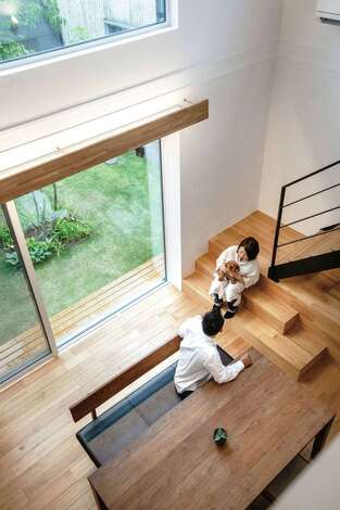 吹き抜けのダイニングで中庭を眺めながら 愛犬と一緒にひと休み クルミの無垢の床の感触が心地よい オリジナルの換気システムによって家の中の空気