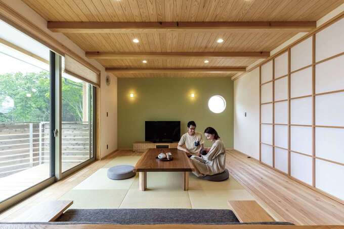 無垢の杉板を惜しみなく使ったリビング 大きな窓から四季折々の庭の景色が見えて 外と中のつながりを感じながらゆったりと過ごせる 丸窓とグリーン