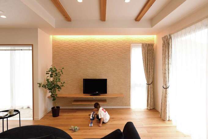 折上げ天井のリビング テレビステーションのエコカラットに間接照明をあててニュアンスを出している イエタテ