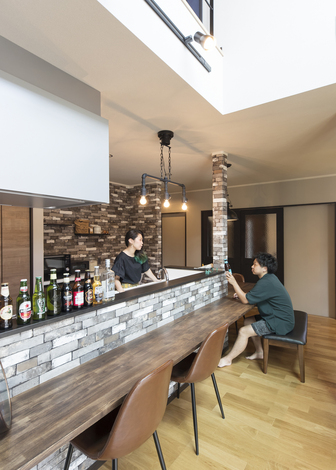 クロスや照明にこだわり 小洒落たバーのようにムーディな雰囲気を演出したダイニングキッチン 対面キッチンの周りに造作のカウンターテーブルをl字