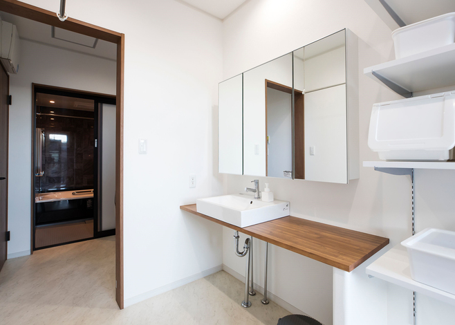 シンプルなデザインに仕上げた造作洗面台 脱衣室とは引き戸で仕切れるようになっている 脱衣室の横には収納とファミリークローゼットがあり 洗濯の