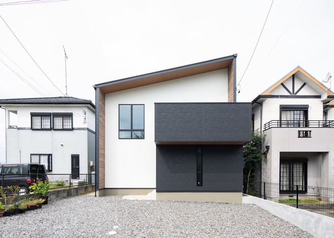 片流れのスタイリッシュな外観デザイン 白とグレーのサイディングがバランス良く調和し 落ち着いた佇まいをみせている 大きな窓がスキップフロアの