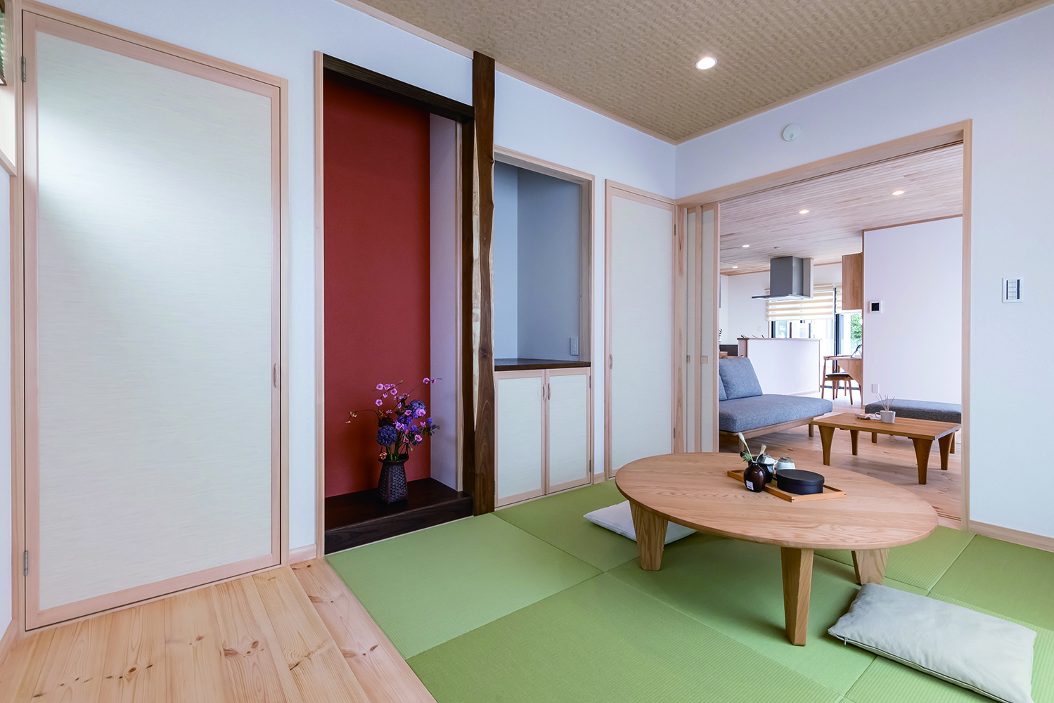 住まいるコーポレーション【二世帯住宅、自然素材、省エネ】4畳半の縁無し畳と板張りの床を組み合わせた和室。床の間の赤壁が端正な和の空間をモダンに演出している