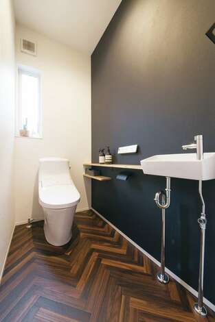 トイレはヘリンボーンの床と黒い壁でシックな雰囲気に テイストをガラリと変えて 遊びを加えた イエタテ