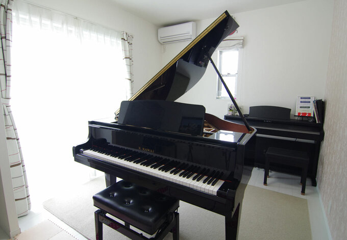 奥さまはピアノ教室を開いておりグランドピアノが置ける部屋を希望 落ち着いた雰囲気の中で生徒さんがピアノを楽しめるよう 1面のクロスを淡い色の