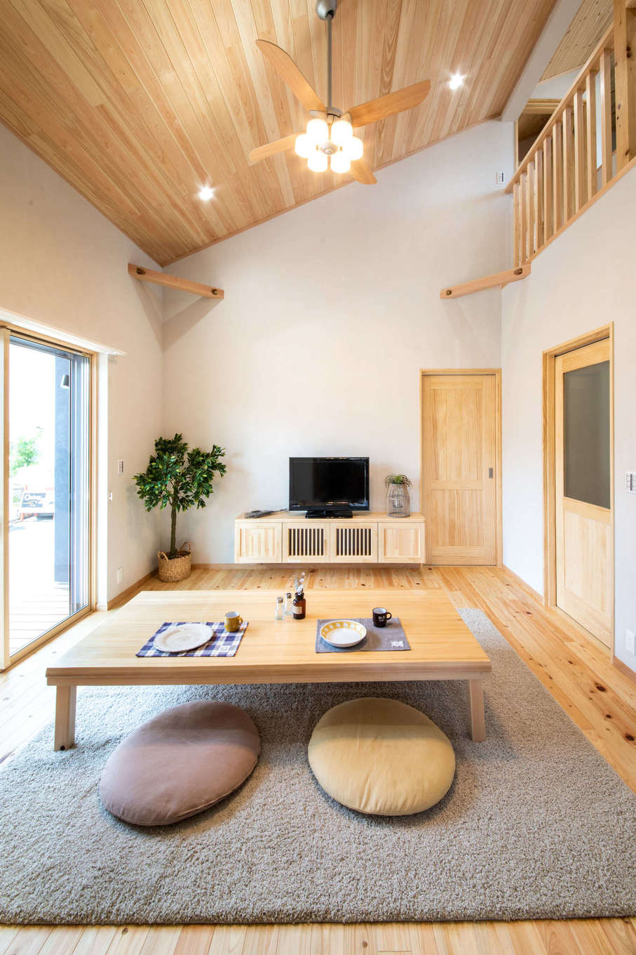 勾配天井のリビング、床はヒノキ、天井はパイン材。吹抜けで2階とつながっているのでコミュニケーションも取りやすい。ロー
