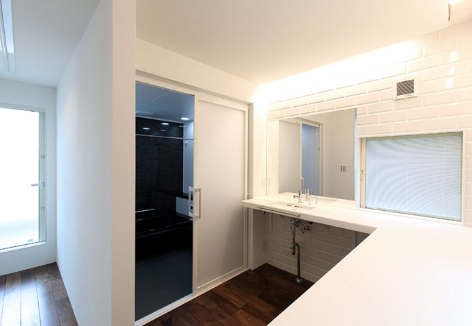 2階の洗面コーナーはカウンターをl字型に配置してあるので アイロンがけや洗濯物をたたむのにも便利 左手奥がバルコニーになっていて動線も考慮