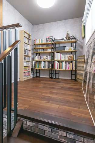 階段を上がった先にあるフリースペース 壁に本棚を造作し 夫婦の愛読書や雑誌 写真集 コミック Dvdなどがずらりと並ぶ イエタテ