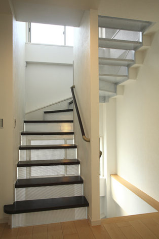 お洒落な鉄骨のストリップ階段には小さい子どもが落ちる事が無いようにパンチングメタルを付け安全対策もしている イエタテ