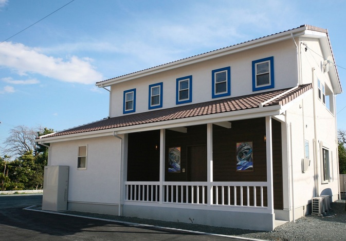 真っ白な外壁に青い窓枠が映える外観 イエタテ