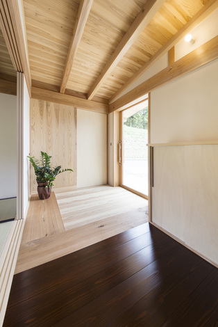 玄関の土間部分は無垢の杉板 ここまでが土足で 木地になる栗の木のラインで靴を脱ぐ 段差はない ガラスの玄関扉を採用したことで明るさも十分確保