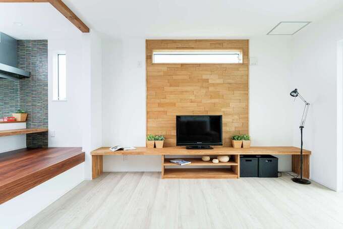 木製の壁と造作のテレビボードでナチュラルなぬくもりが添えられている イエタテ
