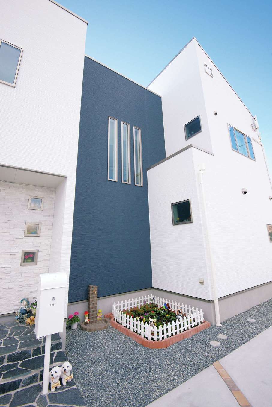 玄関ポーチは凹ませ 右側の棟は1階を張り出させるなどユニークな形がn邸の特徴 空いたスペースにかわいらしい花壇を作った イエタテ