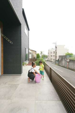 リビングから連続するタイルテラスは ウッドデッキほど熱くならないので子どもたちも安心 奥には家庭菜園もあり 四季折々の野菜を収穫する イエタ