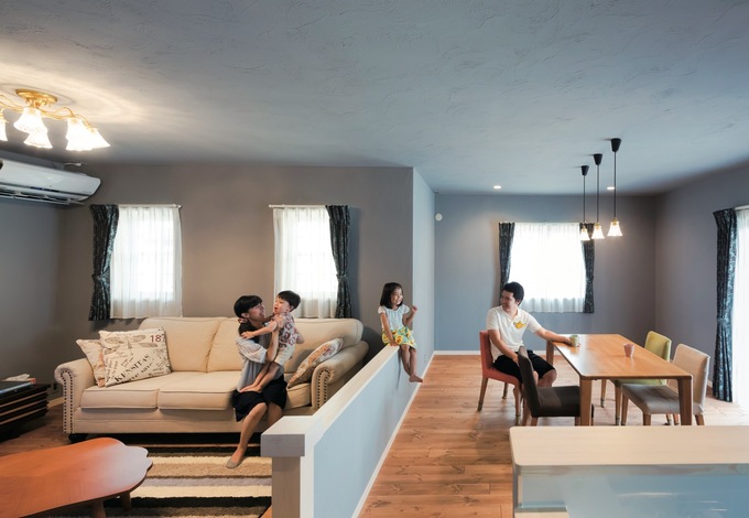 リビングとダイニングを低い壁でゆるやかにゾーニング 北欧風のブルーグレーの塗り壁と無垢の床が絶妙に融合し 落ち着いた雰囲気を演出 吹付け断熱