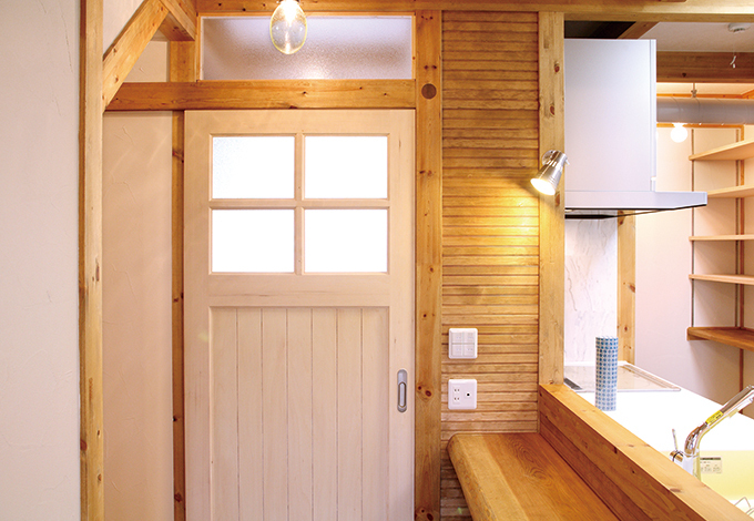 玄関に通じるドアをホワイトのカントリー調にして ウッディな広い空間にアクセントを付けた イエタテ