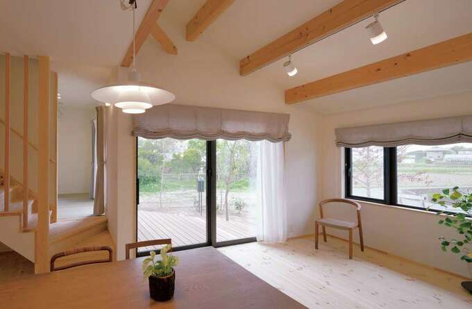 勾配天井が開放感を生むリビングダイニング 大きな窓越しの庭や リビング階段の向こうにある和室までを見渡せる イエタテ