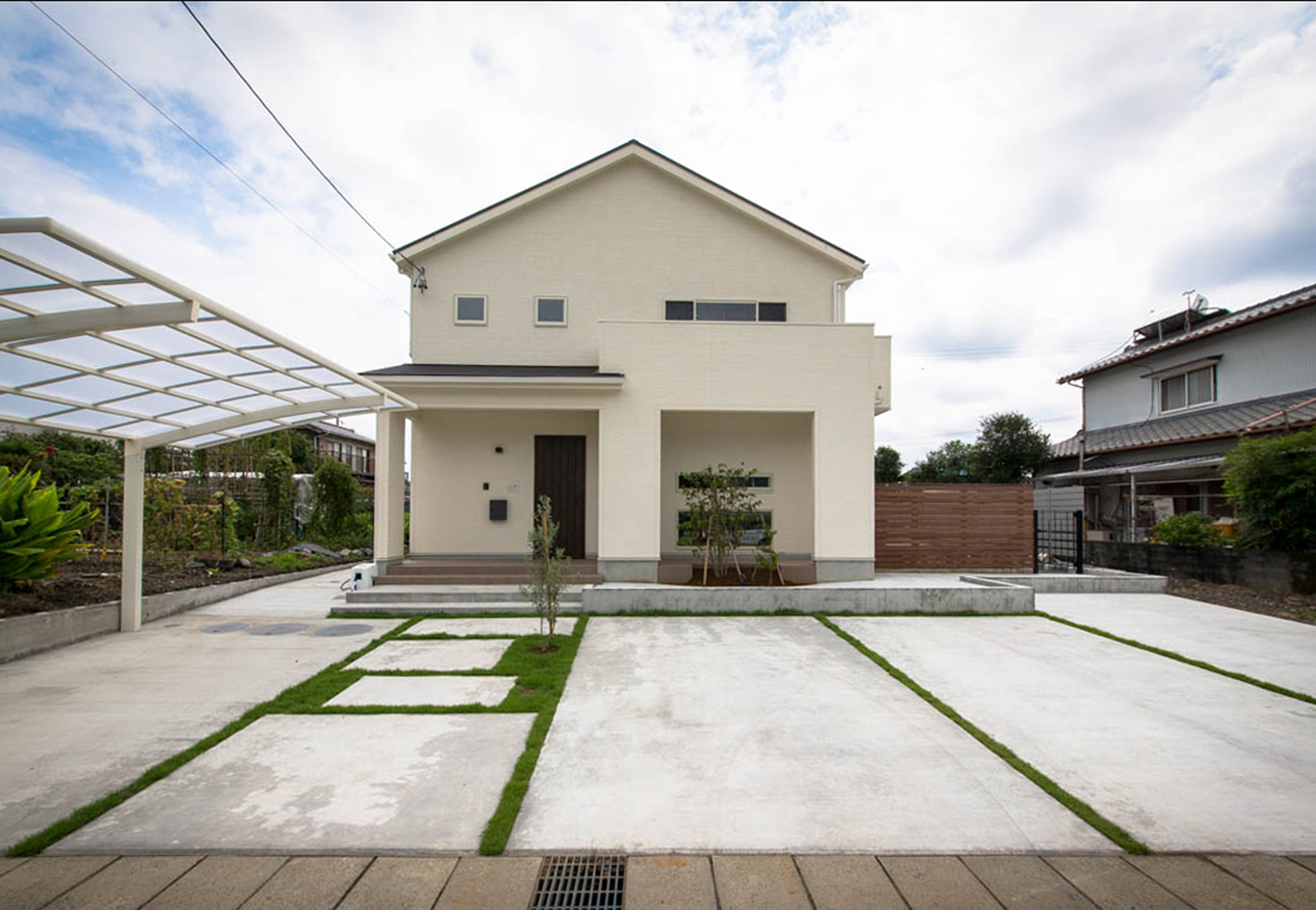 切妻屋根と四角いフォルムをバランスよく配した シンプルな外観 玄関周りは屋根付きの部分が広く便利に使えそう 庭は木塀で目隠ししてプライベート