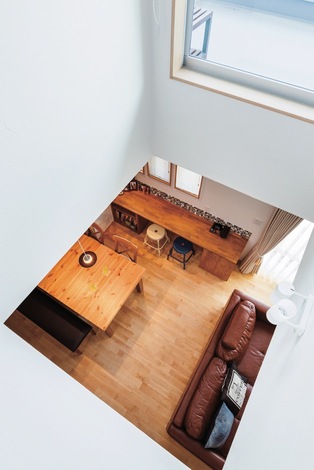 上下階を繋ぐ吹き抜け バルコニーに面した大きな窓から 日中の明るい光を階下に届ける イエタテ