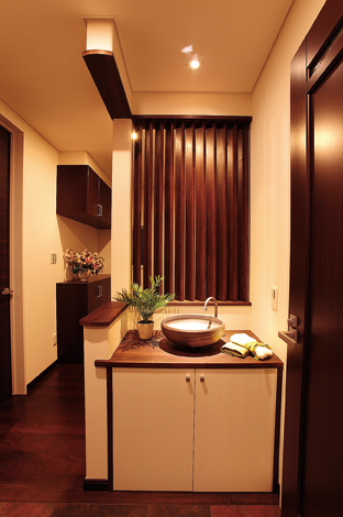 玄関ホールに配された洗面 斜めの格子が視線を遮りながら光を運ぶ イエタテ