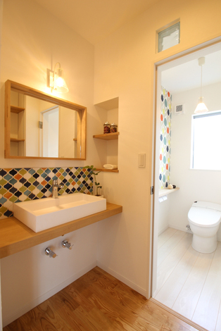 手洗い場のタイルに合わせトイレの壁面も同色系でコーディネート イエタテ