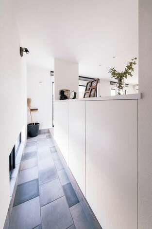 玄関とリビングをつなぐ細長い土間が建物の奥行き感を強調 自転車置き場