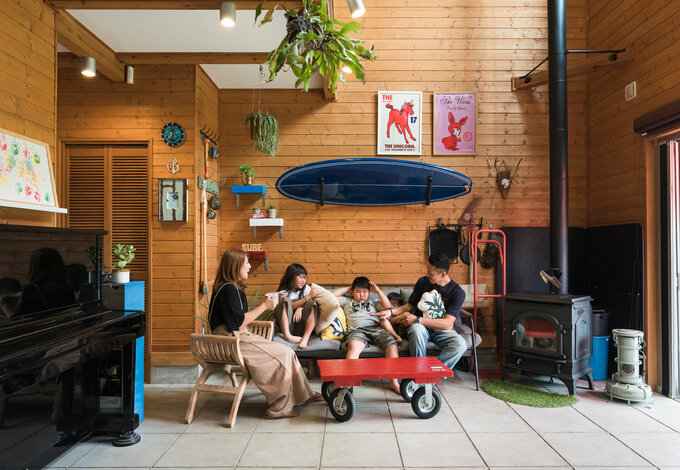 壁に飾られたサーフボードやイラスト グリーンなど Hさん夫妻の好きなものをディスプレイした土間リビング 広い土間でdiyをしたり 自転車に乗