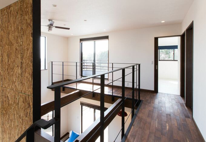 L字になった2階廊下の先にはふたりの部屋とウッドデッキが続く 手すりのアイアンは アーチ のオリジナルデザイン イエタテ