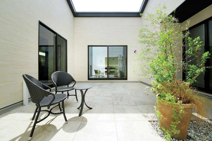 気兼ねなくバーベキューも楽しめるプライベートな中庭 夜間の使用を想定し 壁には照明を設置している イエタテ