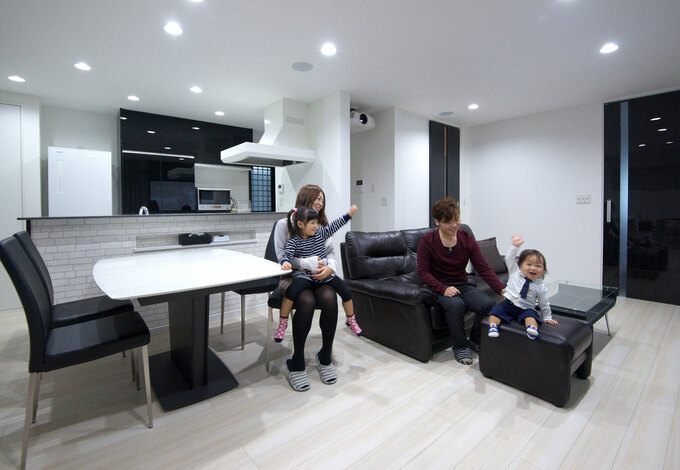 正方形のゆったりとした広さが理想だったという奥さまの希望が叶ったリビング 床 壁は白を基調として 建具や家具に黒を用いたモノトーンの空間 イ