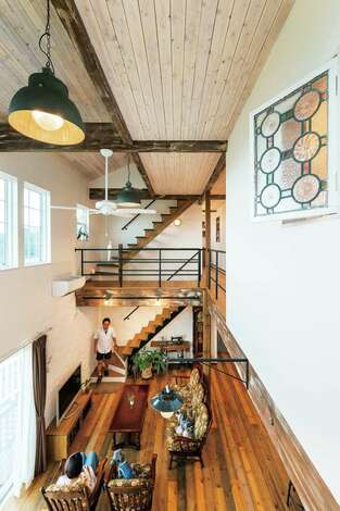 2階キャットウォークから吹き抜けを見通す 天井の板は木目が見える程度に塗り 開放感にあたたかみをブレンド 照明はベルギーの工場で使われていた