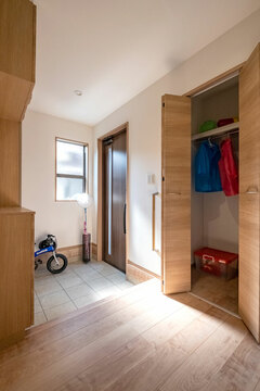 リビングに置きがちな上着 カバンなどを収納するコートクロークは 玄関に配して子どもが使いやすい高さに 土間へ降りずに靴まで手が届く 横長の上