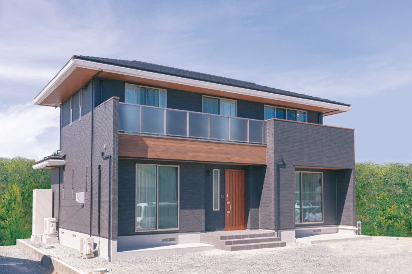 濃いグレーの外壁に木目が映える外観 玄関ポーチの階段を幅広くとり 格調高い雰囲気に 住まいるコーポレーション わたしの住まい