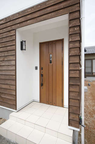 鎧張りの外壁の素材感が個性を放ち コンパクトでありながらインパクトのある玄関ポーチ イエタテ