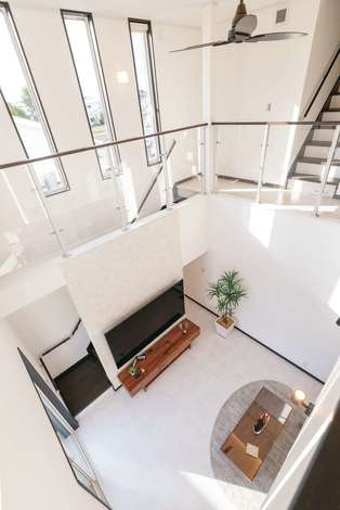 2階ホールは壁の一部に透明板を用いて 圧迫感を排除 階段のスリット窓からの光を階下にも届ける 階段下のデッドスペースにあたるテレビボードの背