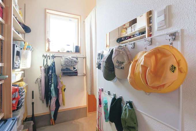 玄関の壁には巨大なホワイトボードを取り付け マグネットフックで帽子類をずらり整頓 傘用ラックもaさん自ら設置し 帰宅時に子どもたちが自分で片