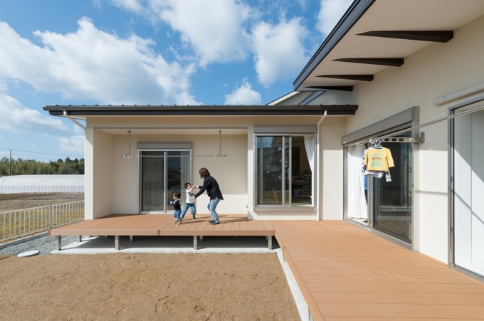 ウッドデッキをl字型にしたことで 寝室やランドリールームからそのまま出ることができ 布団や洗濯物干しも楽々 深い庇はモノトーンデザインにして