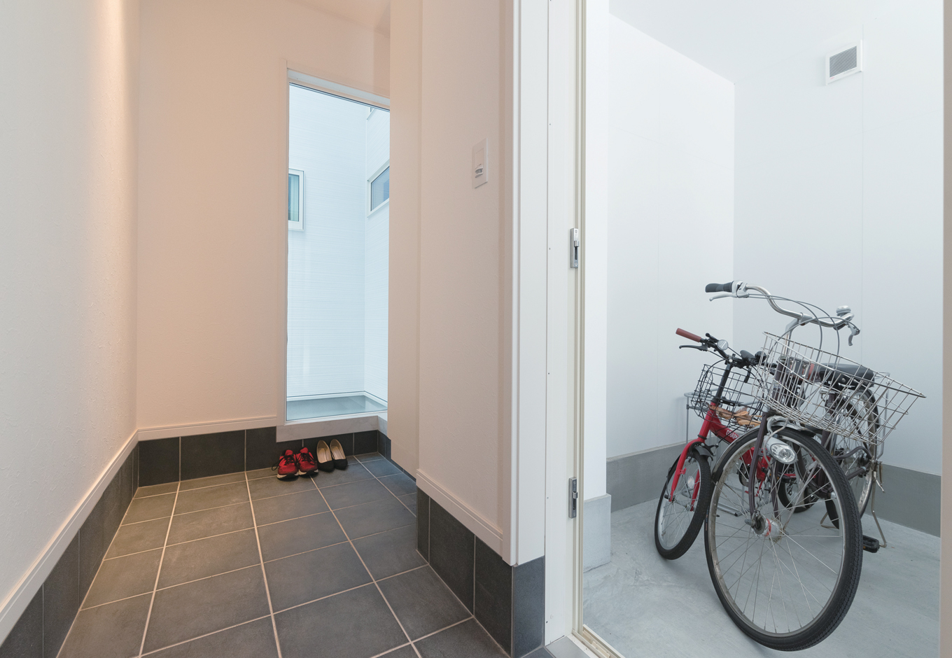 ガレージからも出入りできる玄関 窓の奥に中庭が見える イエタテ